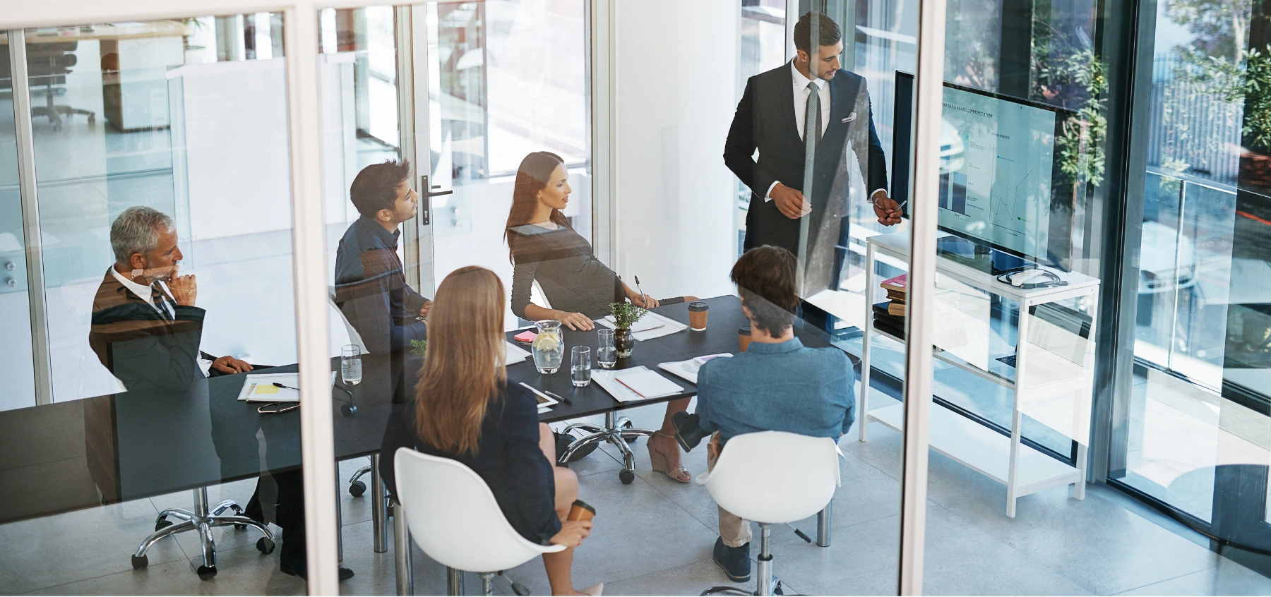 Geschäftsleute sitzen in einem modernen Konferenzraum und besprechen Strategien zur Leadgenerierung.